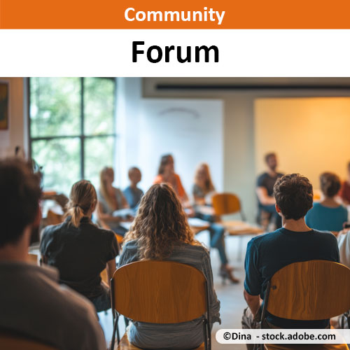 Viele Menschen sitzend auf Stühlen in einem Veranstaltungsraum